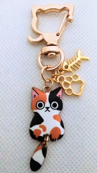 ゴールドの魚の骨と肉球とゆらゆらしっぽのミケの猫キーホルダー