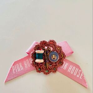 ちっちゃな糸とボタンとハサミが付いた可愛らしい茶色のブローチとピンク色のリボン
