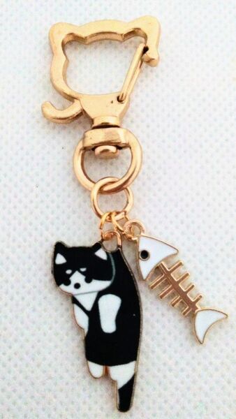 白色の魚の骨とちょっとでっかいつままれちゃった黒ハチワレの猫キーホルダー