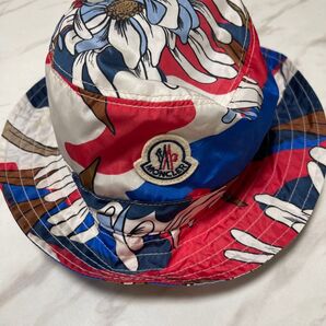 モンクレール(MONCLER)のバケットハットです。モンクレールらしいロゴ総柄とワッペンが目を惹きとても可愛らしいデザインです。