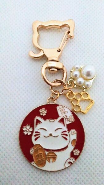 パールとゴールドの肉球と紅白の小判を持った福を招く猫キーホルダー
