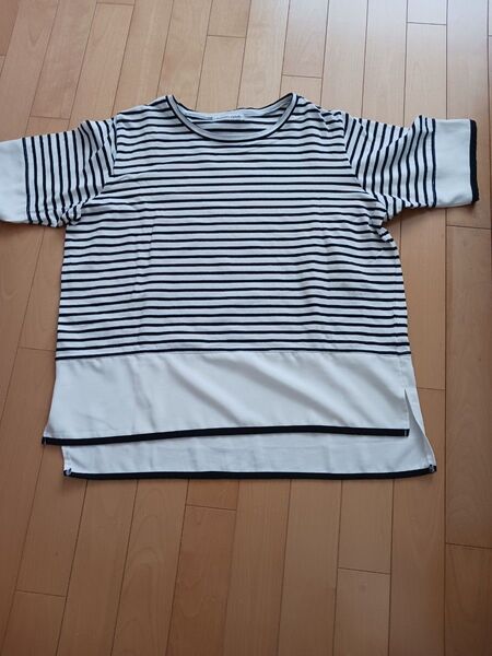 白と黒のストライプデザインの半袖Tシャツ。裾に白の切り替えが特徴。- : Alphabet's alphabet