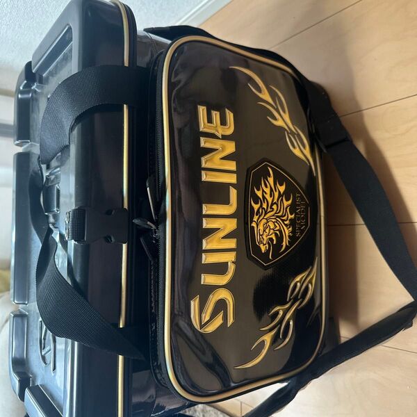 SUNLINEのブラッククーラーボックス、持ち運びに便利なストラップ付き。