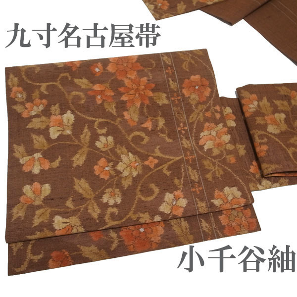 名古屋帯 九寸 小千谷紬 紬 手織り こげ茶色 朱赤 花唐草 カジュアル 上質 上品 帯 正絹 絹 春秋冬 美品 なごみ 中古 仕立て上がり kp2028