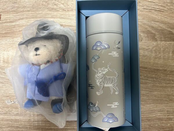 虎と雲のデザインが施されたステンレス製の水筒と、青い着物を着たクマのべアリスタキーホルダーのセット