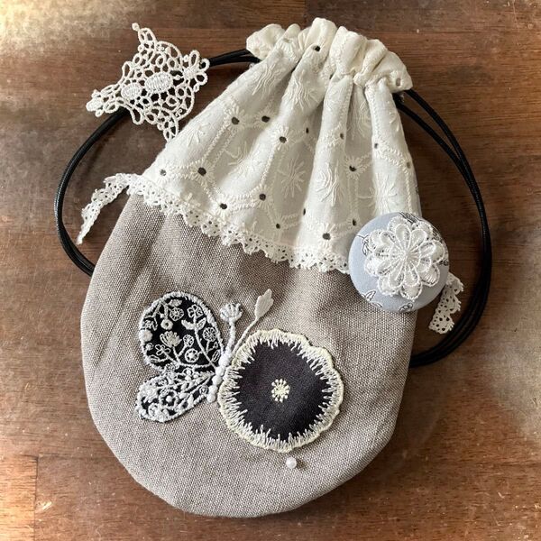 ミナペルホネンハンドメイドforest wingとjelly flowerの巾着。ブローチ付き。