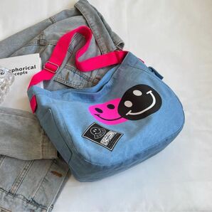 クロスボディ餃子バッグ女性カウガールバッグ2025新型夏ニッチ笑顔文芸ショルダーバッグワイドショルダーキャンバスバッグ