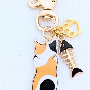 黒色の魚の骨とのびのび後ろ姿のミケの猫キーホルダー