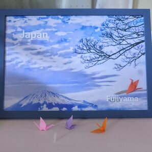 平和と祈りをイメージして自身が撮影した写真を色付け加工し折り鶴をフレームの中に収めました。。
