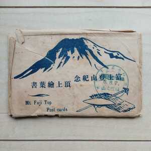 ■『富士登山紀念頂上繪葉書』９枚嚢付。８枚に昭和7年8月6日付「鎮國之山頂上登嶽紀念」の消印有り。◎嚢に瑕疵有ります。