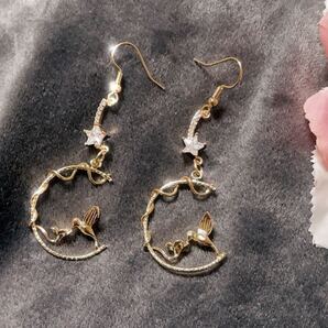 花に触れる鳥と流れ星のようなスワロのピアス