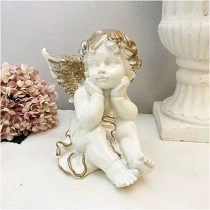 Figurine d'ange antique décorée en or blanc reposant sur son menton.Figurine d'ange posée sur son menton., œuvres faites à la main, intérieur, marchandises diverses, ornement, objet