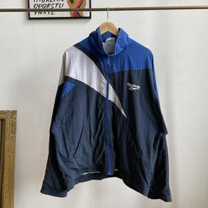 古着 90s Reebok ナイロンジャケット リーボック フロッキーバックプリント SV-ORTSGRUPPE TIENGEN ベクターロゴ ブルー XL C74