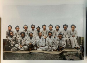 1909年、朝鮮軍起義軍官処刑前の写真、各受刑者の胸の前に番号、氏名はなし。ハイテクデジタル着色、製作者サイン入り。40.6×30.5 cm