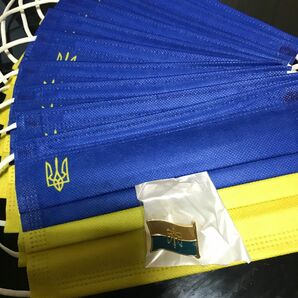 ウクライナ応援、連帯、デモ用、国章入りマスクカバー１０枚とウクライナ国旗型ピンバッジのセットです。大幅に値下げします。