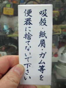 表示板「吸殻・紙屑・ガム等を便器に捨てないでください」