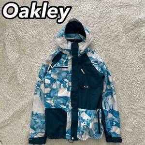 OAKLEY オークリー スノーボード スノボ スキー ウィンタースポーツ スノーウェア パーカー ジャケット L/G 水色 総柄 男性 メンズ
