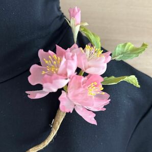 桜のコサージュ白い布を染めてお花や葉を作りコテをかけて表情を出しています。中の花芯も染めています。ハンドメイドです。