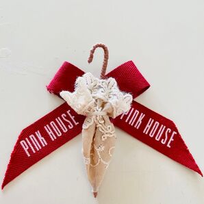 ベージュの刺繍レースのアンブレラと赤色リボンのブローチ