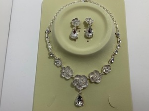  largish rhinestone attaching . flower motif shines . necklace + swaying earrings 