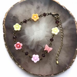 ハンドメイド アクリルお花と蝶々とボタンカットビーズのブレスレット 暖色系の画像1
