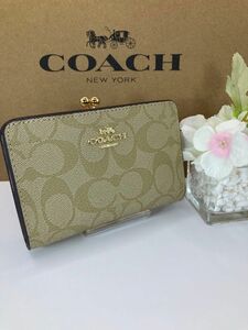 新品　未使用　COACH コーチ ベージュシグネチャー　がま口二つ折り財布　箱、紙袋付き