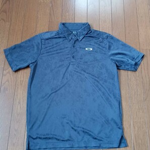 K-56 【中古】OAKLEY オークリー　ゴルフウェア　半袖　ポロシャツ　紺色　総柄　左胸にオークリーのロゴ　メンズ　サイズ　L　冷やり素材