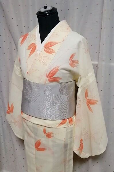 夏着物 単衣 絽 ポリエステル 洗える着物 淡い黄色地にオレンジ色の木の枝葉柄 袖口・左右前身頃にしつけ糸があり