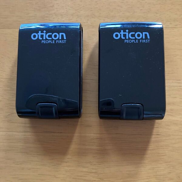 oticon PEOPLE FIRST と書かれた補聴器の入れ物と思われるケース2個になります。布と用途の分からない棒状のもの1本