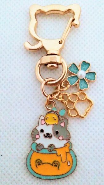 パール付き水色のお花と肉球とミツバチをのせたハニーポットからひょっこり猫キーホルダー
